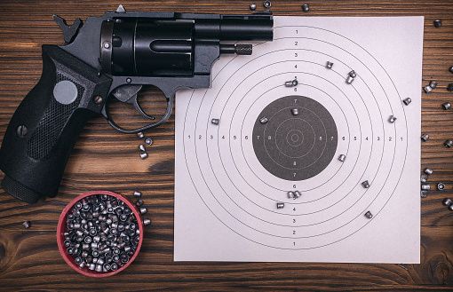 Gun pistol and paper target. Shooting practice. Shooting range background with copy space.