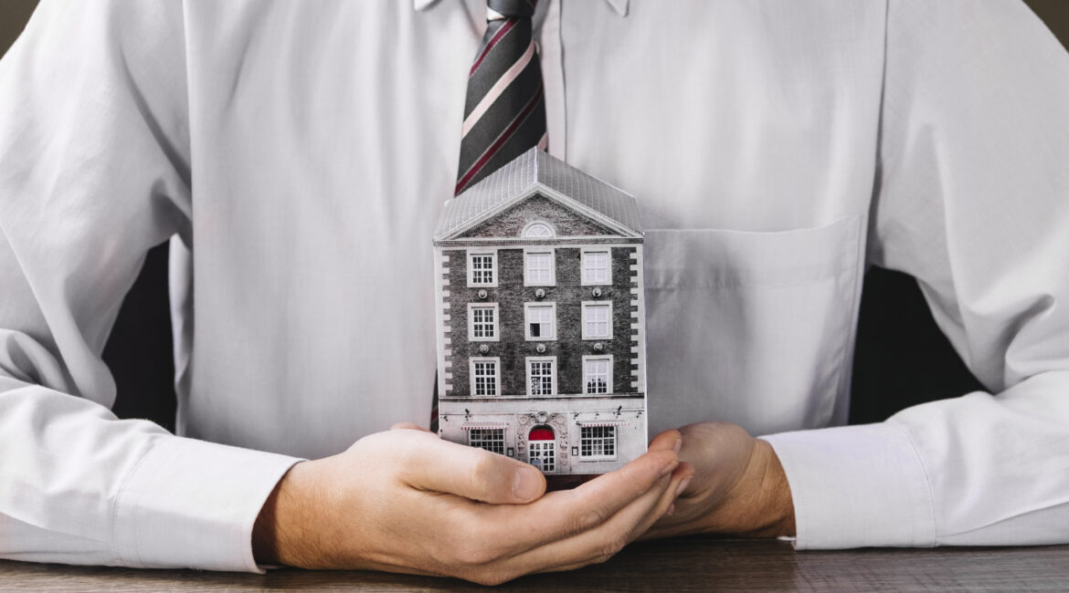 man holding miniature house hands